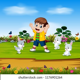 vector illustration of the boy are playing with three rabbits in the garden