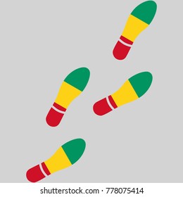 Vector illustration of chain of trails of shoes isolated on grey background, painted in the colors of national flag of Guinea