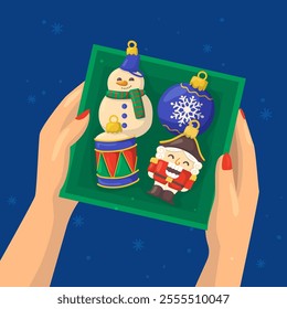 Vector illustration of a hand holding a box with Christmas ornaments snowman, nutcracker, drum, ball.