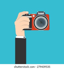 Vector illustration of a hand holding digital SLR camera for your design