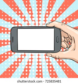 Vector illustration of hand horizontally showing mockup smartphone blank screen, Illustration in sketch retro style on pop art background of rays and halftone dots