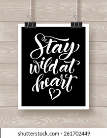 Vector illustration with hand-drawn lettering on wood background. "Stay wild at heart" poster or postcard. Calligraphic design