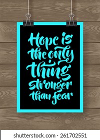 Vector illustration with hand-drawn lettering on wood background. "Hope is the only thing stronger than fear" poster or postcard. Calligraphic design