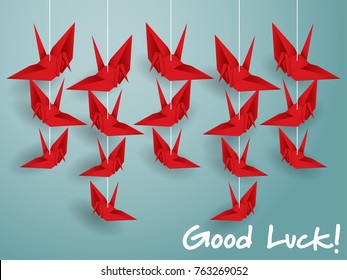 Vector illustration of hanging origami paper cranes in red color and "Good Luck!" text on blue background. Flat design style.