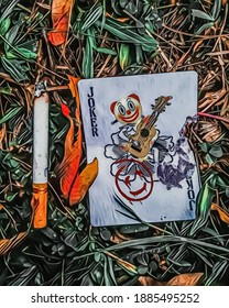 vector illustration of a joker playing card and a cigarette butt on the grass.