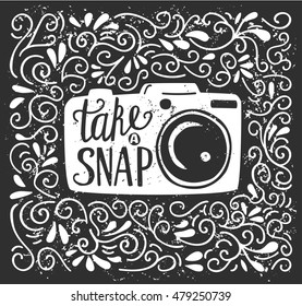 Vector illustration with lettering Take a snap. White photo camera silhouette, hand written phrase and doodle swirls on black background with grunge texture. Typography poster and card design.