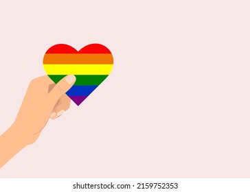 vector illustration lgbt rainbow flag heart holds in hand on pink background copy space. rainbow symbol of the LGBT community, a lesbian, gay, bisexual and transgender organization.