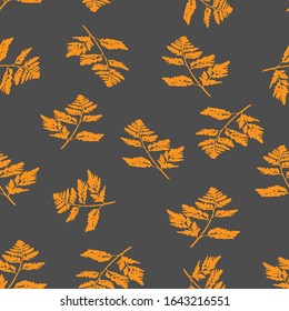 A vector Illustration of orange carved fall leaves isolated on a gray background, Seamless pattern