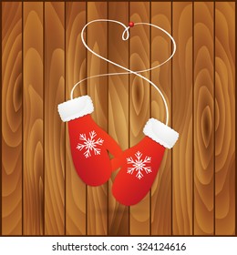 Vector illustration pair of red christmas mittens on wooden background. Mitten icon. Christmas greeting card with mittens.