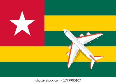Vector Illustration of a passenger plane flying over the flag of Togo. Concept of tourism and travel