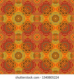 Vector illustration. With saturated shapes in orange, yellow and brown colors. Seamless pattern abstract background. Textile design texture. Ethnic tracery for print on textile.