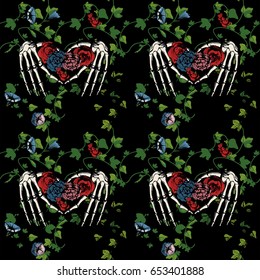 Vector illustration, seamless pattern of a skeleton hands making heart, surrounded and covered with plants and flowers on black background. Vintage engraving style