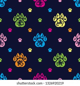 Vector illustration seamless texture composed with colourful dog paw prints on a dark blue background. Multicolour repeat pattern for the animal lover. Seamless pattern.