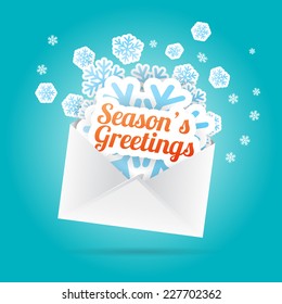 Vector illustration of season's greetings and snowflake cutouts from an envelope.