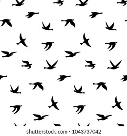 Vector illustration of silhouette of birds. Seamless pattern with black isolated flat contours of flying birds. Design element for logo, print, card, flyer, fabric, poster.