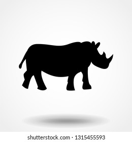 Vector illustration of a silhouette of a rhino standing on isolated white background. Rhinoceros side view profile.