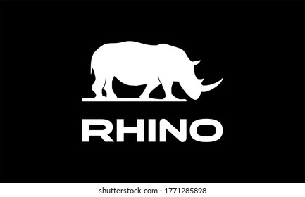 Vector illustration of a silhouette of a rhino standing on isolated white background. Rhinoceros side view profile.