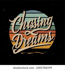 Vector illustration with a sunset background that says "Chasing Dreams" in a warm color calligraphy style suitable for t-shirts. hats, mugs and more