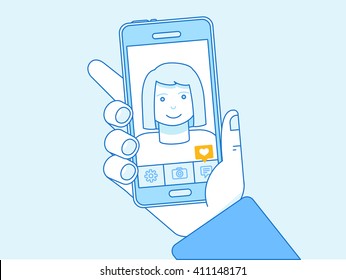 Vector illustration in trendy linear style and blue colors - selfie concept - hand of a woman taking photo and self-portrait - photo editing and sharing app on the screen of the mobile phone