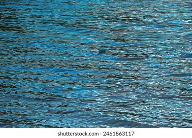 Vector illustration of water ripple texture background. Wavy water surface during sunset, golden light reflected in the water.
