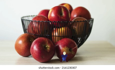 Ilustración vectorial Cuero de cables lleno de manzanas rojas. Tres manzanas se sueltan delante de un tazón. Un hombre descansando se apoya en una manzana. Vitaminas, salud y belleza.