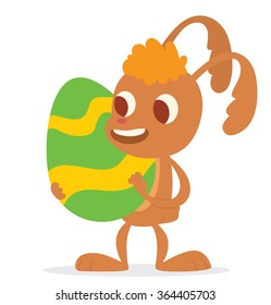 Vector image of cartoon funny light brown Easter Bunny with orange forelock with a big colorful Easter egg in his paws on a white background. In the theme of Easter. Vector illustration.