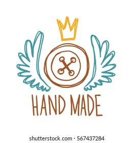 Vector image of the emblem of handmade from the big brown button, white wings and golden crown on a white background. Needlework, craft. Inscription "Hand Made". Vector illustration.