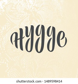 Vector inscription Hygge. Danish word Hygge means lifestyle with coziness and comfort. Typography poster. Scandinavian style. Minimalistic design. Pale pink lace textured background. Calligraphy.EPS10