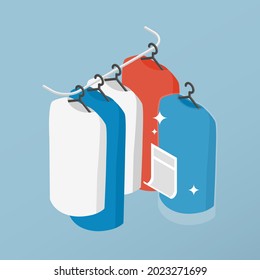 Vector isometric clean clothes concept illustration. Clothes on the hangers after professional dry cleaning concept.