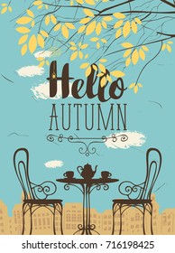 Vector landscape in retro style on the autumn theme with the words Hello autumn, furnished outdoor cafe, two cups and a kettle and autumn tree on a background of an old European city