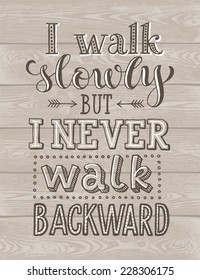 Vector lettering on wood background. "I walk slowly but I never walk backward" poster or postcard. Typography collection 