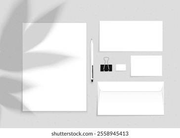 Vector mockup of office stationery with plant shadow on a gray background. Pen, A4 sheet, scissors, envelope, set.