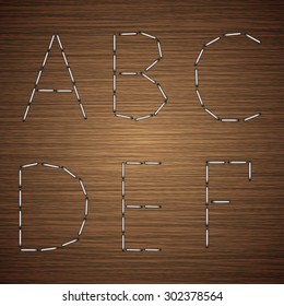 Vector modern staples alphabet on wooden background