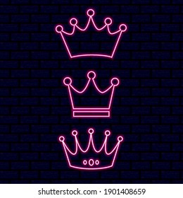 Vector neon crown. Set of different shapes of neon crowns. Pink neon light on a brick background. Brick wall.