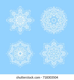 Vector ornate snowflake set. Illustration of white mandalas on blue background