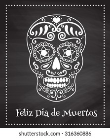 Vector poster with the image of traditional mexican skull and spanish text translated as 'happy dead day' on a chalkboard background