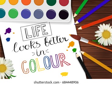 Vector poster with pencils, paints and motivation card on wood table. Life looks better in colour. Positive poster