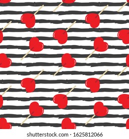 Vector red heart-shaped lollipops on striped seamless pattern background.