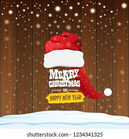 vector red Santa hat with greeting text Merry Christmas and happy new year on wooden background with falling snowflakes. Funny Merry christmas greeting card, banner or poster xmas background.