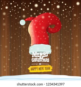 vector red Santa hat with greeting text Merry Christmas and happy new year on wooden background with falling snowflakes. Funny Merry christmas greeting card, banner or poster xmas background.