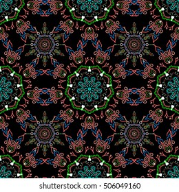 Vector seamless background. Colored patterns antique. Floral ornament in green and red colors on a black background.