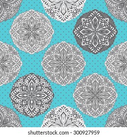  Vector seamless decorative  pattern with geometrical layout. Light grey ornate rosette with ethnic ornament on a turquoise background