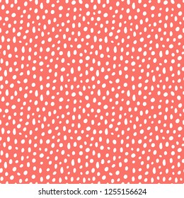 Vector seamless pattern background in trendy color of 2019, living coral, with abstract doodle dots or snow.