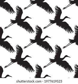 Vector seamless pattern of black hand drawn flying crane bird silhouette isolated on white background