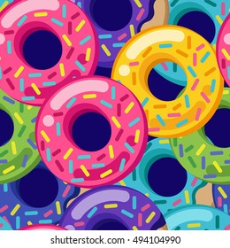 Vector seamless vector pattern with colorful donuts with glaze and sprinkles on a dark blue background. Modern flat geometric donuts set. Yellow green pink lilac and mint. Tasty sweets. Desserts.