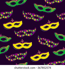 Vector seamless pattern with colorful Mardi Gras face masks on dark violet background for your design. Cute background in green, pink and yellow colors. Hand drawn doodle elements.