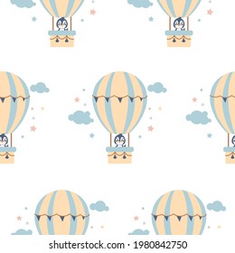 Vector seamless pattern with a cute penguin flying in a hot air balloon among the clouds isolated on a  white background. Perfect for a nursery clothing, postcard,  pyjamas, print.