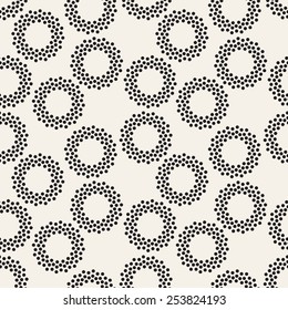 Vector seamless pattern with dotted circles. Stylish background with randomly disposed rings. Monochrome minimalist graphic design. Tileable simple texture from small black dots