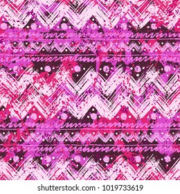 Vector seamless pattern with ethnic and tribal motifs in romantic pink colors. Bold bohemian texture with hand drawn chevrons, brushed lines, watercolor splatters and dots. Print in boho chic style