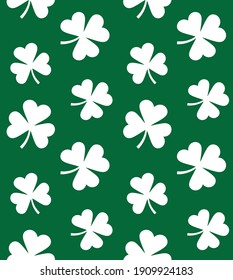 Vector seamless pattern of flat white clover shamrock isolated on green background